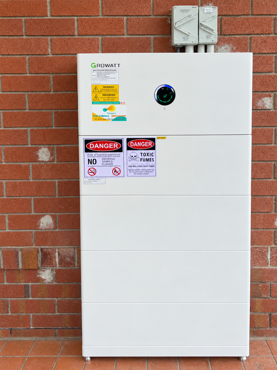 Home battery installation against a red brick wall